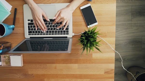 bureau avec une personne qui utilise un ordinateur portable et un smartphone
