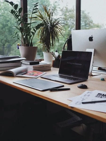 Bureau de travail en équipe avec ordinateurs et plantes vertes